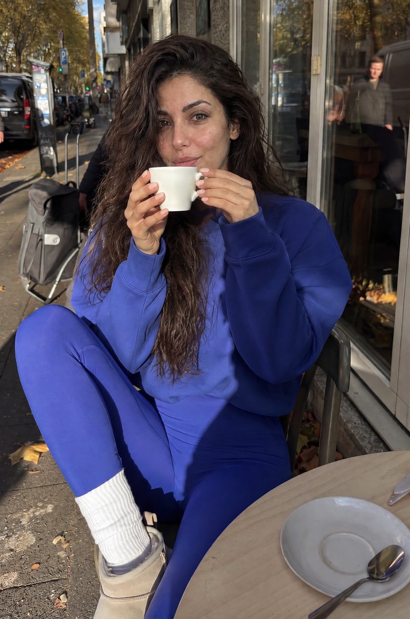 Coffee at a street café in a blue tracksuit